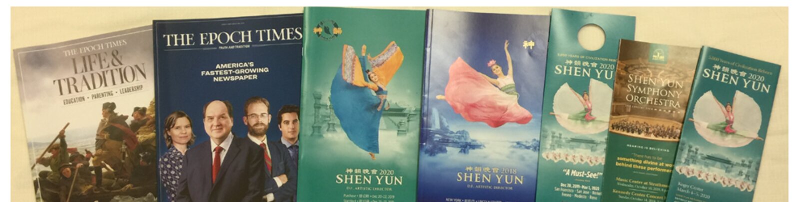 Sample magazine and program work from the Rallity printing network: Epoch Times Life & Tradition, Shen Yun programs, and other titles fanned across a tan surface.